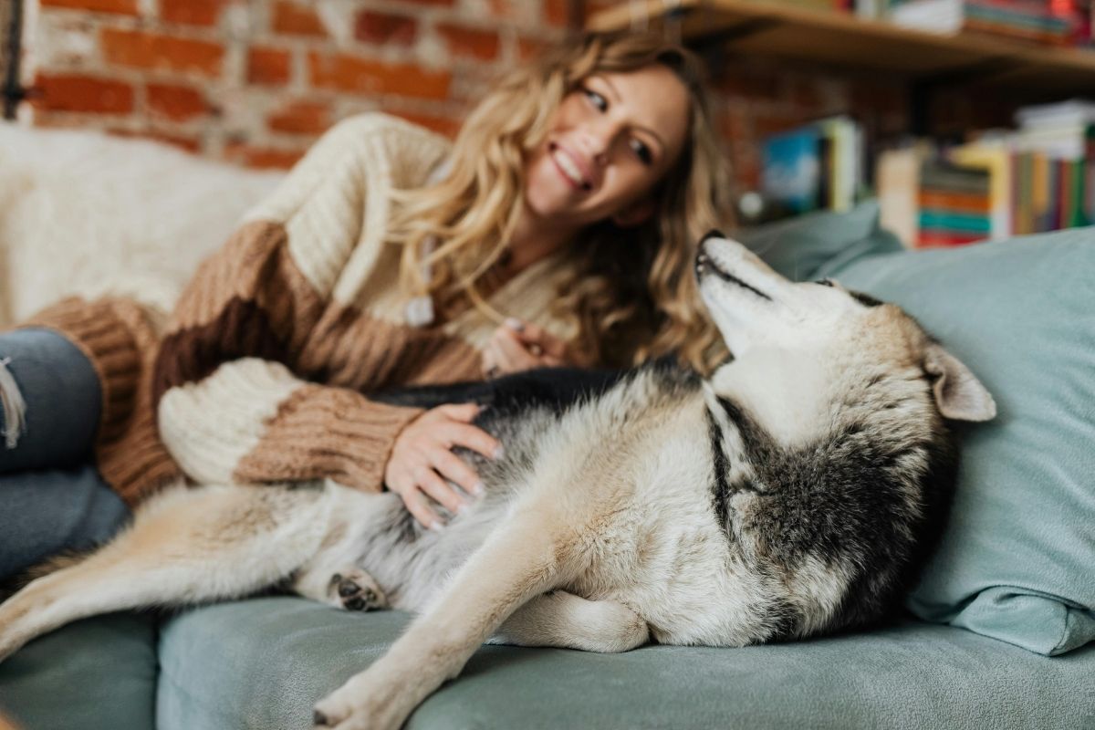 Woman relaxing with dog in a clean home, illustrating the benefits of topical probiotics.